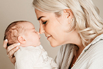 Blonde Mutter mit Baby Nase an Nase
